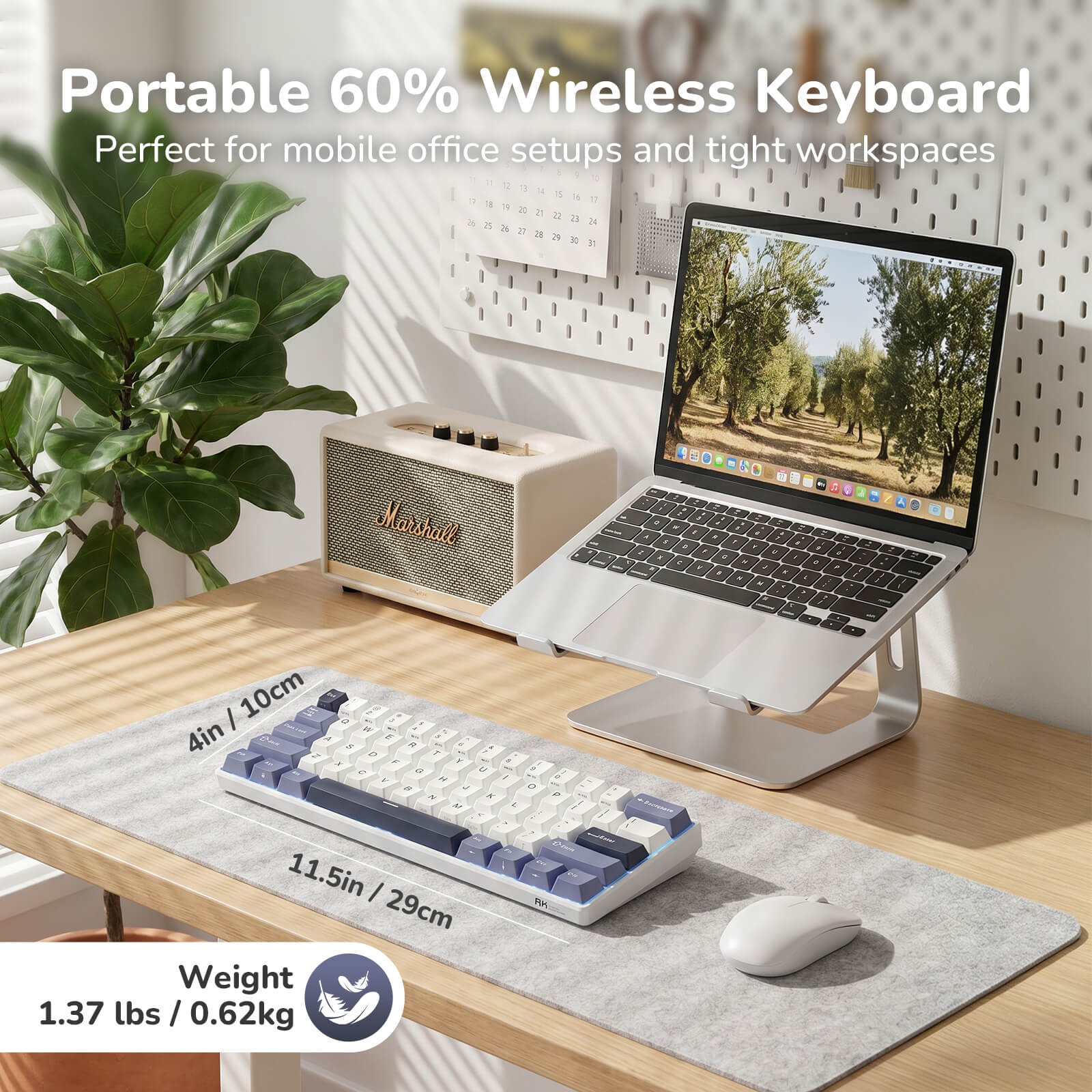 Portable 60% wireless keyboard on a desk with a laptop and plant in the background